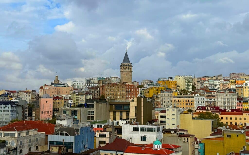 Travel to Turkey featuring the Galata Tower and Istanbul skyline with colorful buildings and cloudy sky